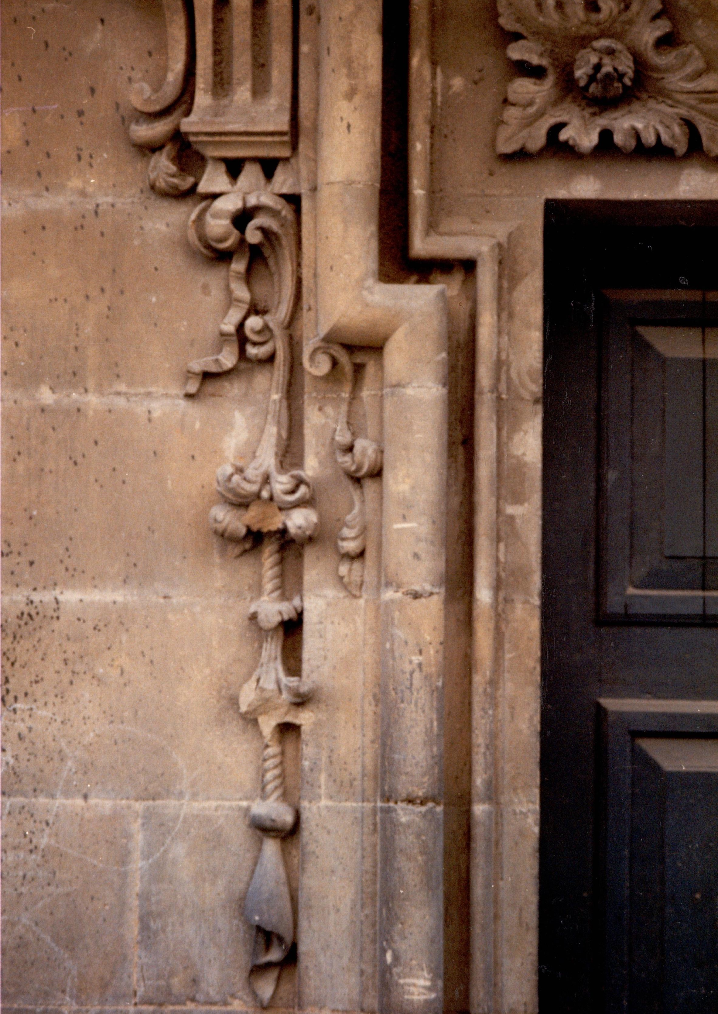 Se muestran los detalles decorativos de una de las puertas del palacio. El color es el de la piedra: arenisca color tostado.