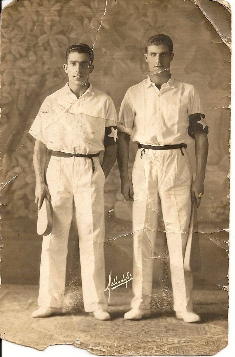 Fotografía en blanco y negro de dos palistas, uno de ellos es Félix Izaguirre Garate, vestido de blanco al completo menos el "gerriko" y un brazalete negro con una estrella blanca. Ambos posan con la pala en la mano.