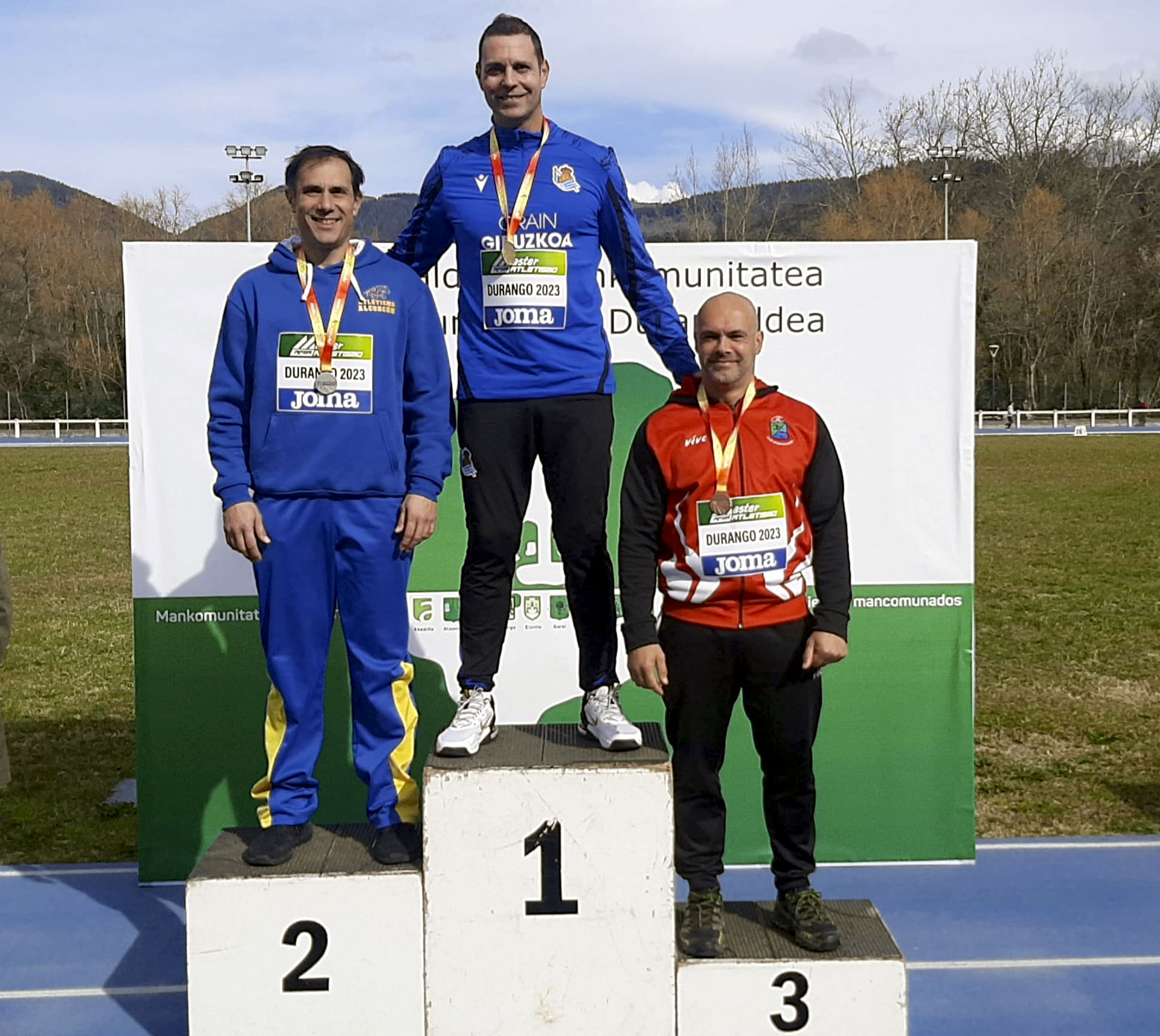 En la foto los tres atletas del podion, con Óscar en lo más alto