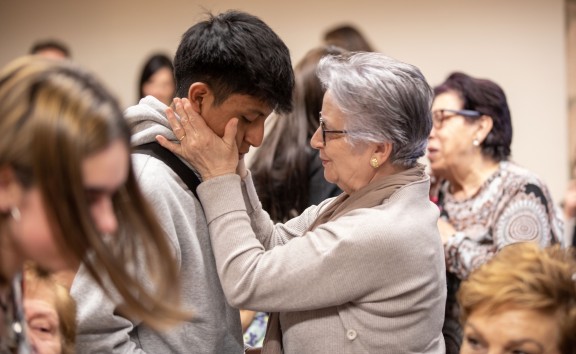 Abrazo entre un alumno y una participante de "Dame tu mano"