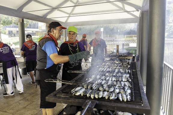 Dos voluntarios frente al asador de brasa