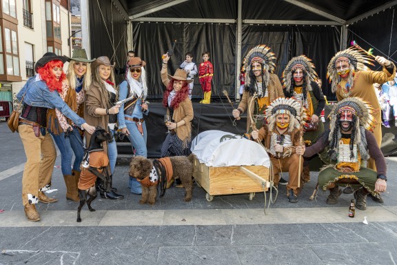 Indios 'Sioux' y vaqueras/os con carromato y mascotas