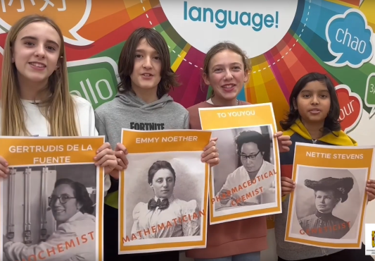 Cuatro alumnas muestran imágenes de mujeres científicas