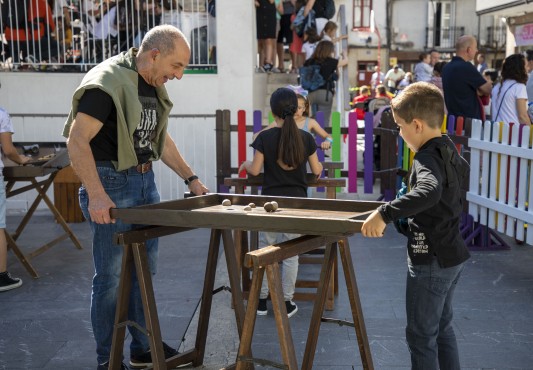 Una persona mayor y un niño juegan en la plaza