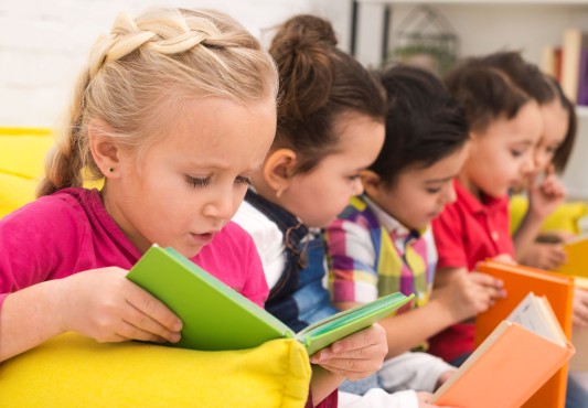 Grupo de niños/as leyendo libros