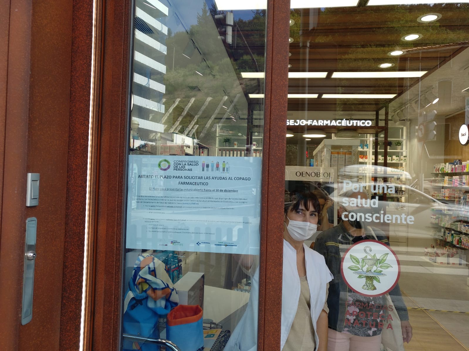 Auxiliar coloca el cartel en el escaparate